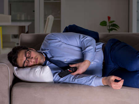 Businessman watching tv at night lateの写真素材