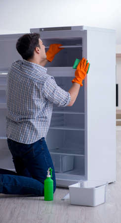 The man cleaning fridge in hygiene conceptの写真素材