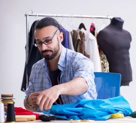 Male tailor working in the workshop on new designs