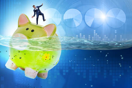 Businessman in debt concept with piggybankの写真素材