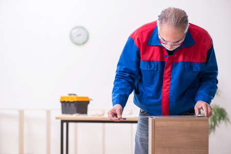 Old male carpenter working indoorsの写真素材