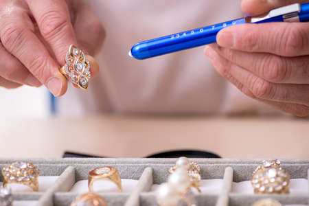 Old male jeweler at workshopの写真素材