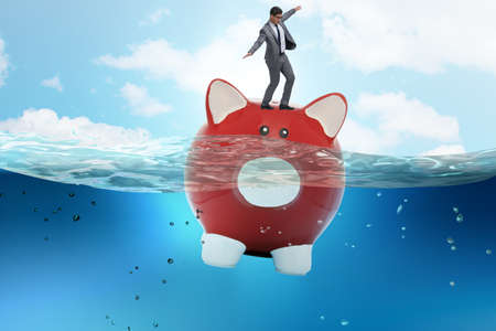 The businessman in debt concept with piggybankの写真素材