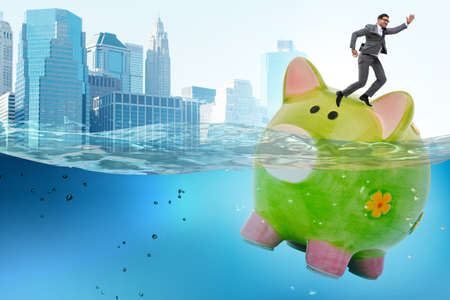 Businessman in debt concept with piggybankの写真素材