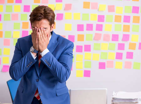 Young handsome man in conflicting priorities conceptの写真素材