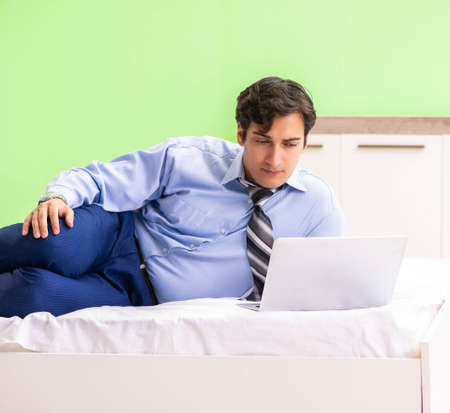 Businessman working overtime in hotel roomの写真素材