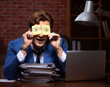 Young businessman working in the office at nightの写真素材