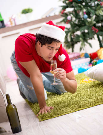 Young man drunk at home after christmas partyの写真素材
