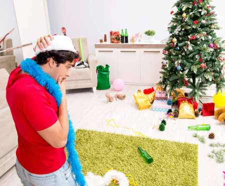 Young man drunk at home after christmas partyの写真素材
