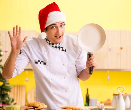 Young chef husband working in kitchen at Christmas eveの写真素材