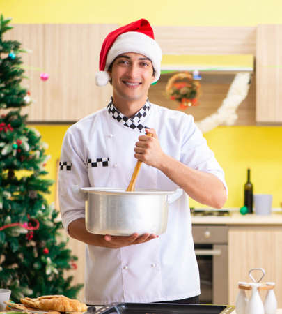 Young chef husband working in kitchen at Christmas eveの写真素材