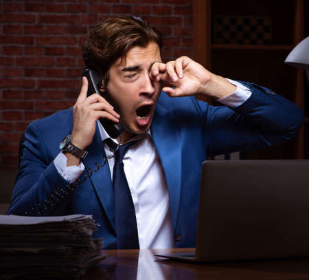 Young businessman working in the office at nightの写真素材