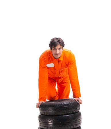 Young garage worker with tyre isolated on whiteの写真素材