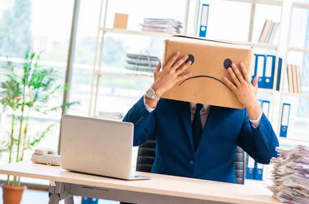 The unhappy man with box instead of his headの写真素材