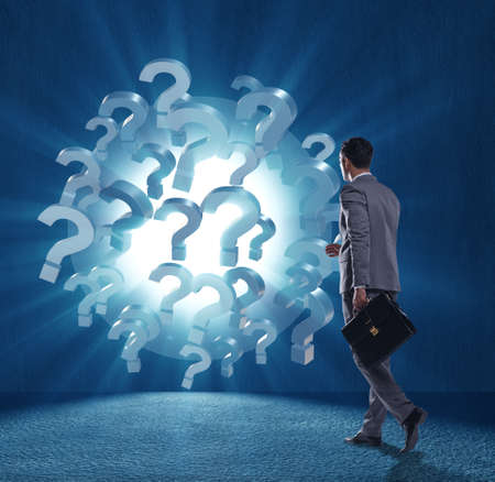 Businessman in uncertainty concept with question marksの写真素材
