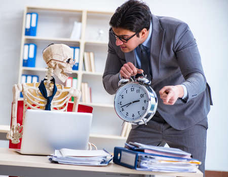 Angry boss yelling at his skeleton employeeの写真素材