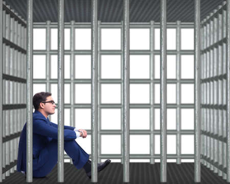 Businessman in the cage isolated on whiteの写真素材