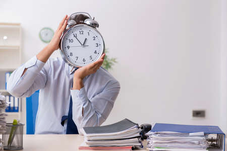 Young male businessman employee unhappy with excessive workの写真素材