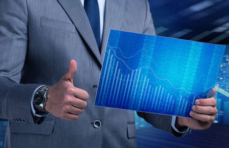 Businessman holding screen with market quotesの写真素材