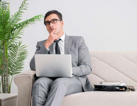 Businessman with laptop notebook sitting in sofaの写真素材
