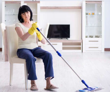 Old mature woman tired after house chores
