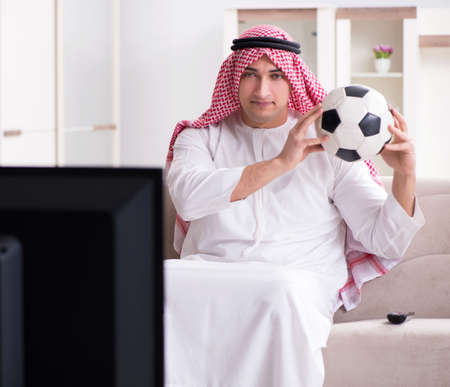 Arab man watching tv at homeの写真素材