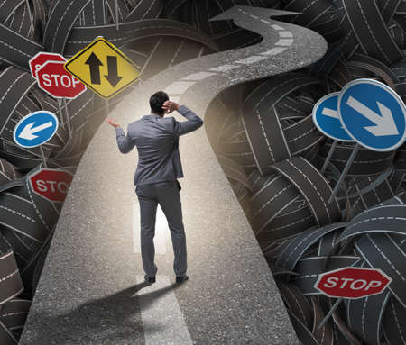 Businessman in uncertainty concept on road intersection crossroaの写真素材