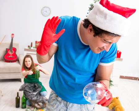 Young family cleaning apartment after christmas partyの写真素材