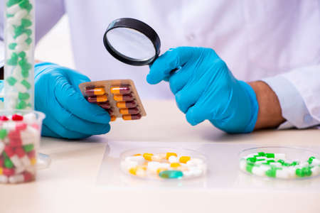 Young male chemist in drug synthesis conceptの写真素材