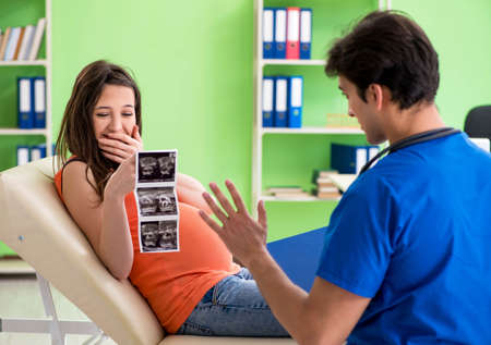 Pregnant woman visiting male gynecologyst at the clinic