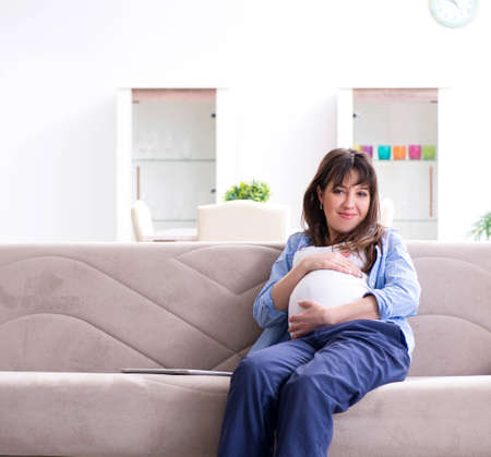 Pregnant woman relaxing on the sofaの写真素材