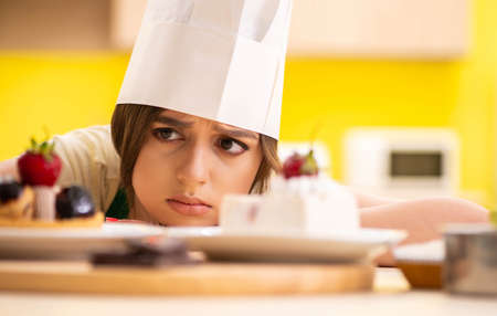 Young cook cooking cakes in the kitchenの写真素材