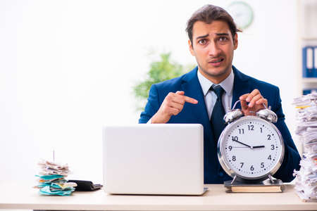 Young male employee unhappy with excessive workの写真素材