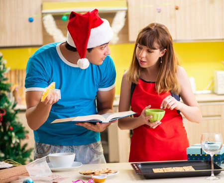 Young couple celebrating Christmas in kitchenの写真素材