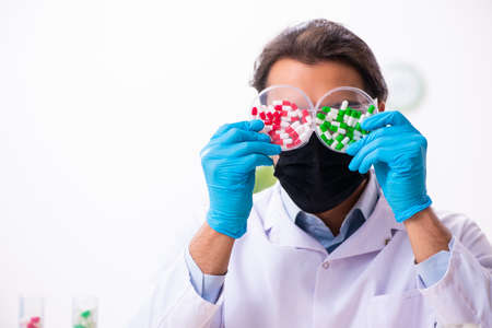 Young male chemist in drug synthesis conceptの写真素材
