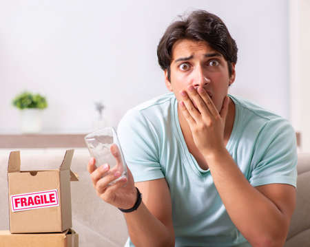 Man opening fragile parcel ordered from internetの写真素材