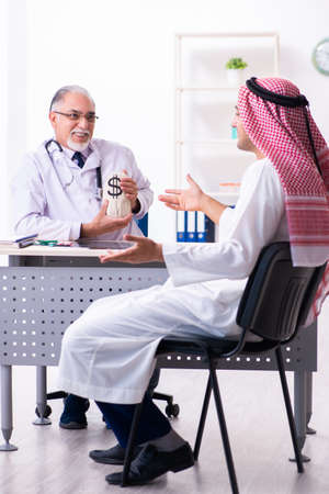 Young male arab visiting experienced male doctorの写真素材
