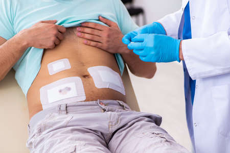Injured man visiting experienced male doctor