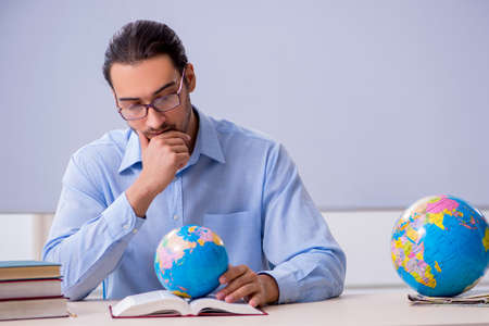 Young male geography teacher in front of whiteboardの写真素材
