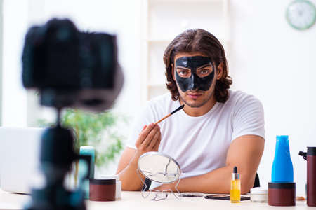 Young male cosmetician recording video for his blogの写真素材