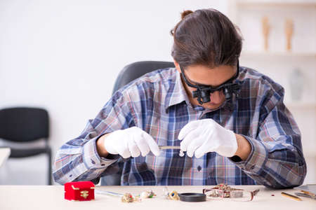 Young male jeweler at workshopの写真素材
