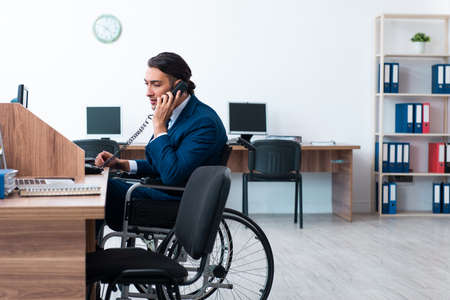 Young male employee in wheel-chairの写真素材