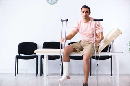 Young injured man waiting for his turn in hospital hallの写真素材