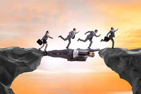 Businessman acting as a bridge in support conceptの写真素材