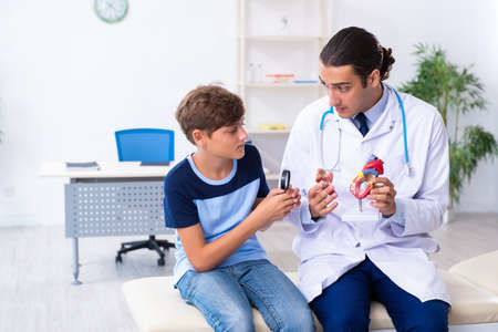 Young male doctor examining boy in the clinicの写真素材
