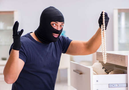 Robber wearing balaclava stealing valuable thingsの写真素材