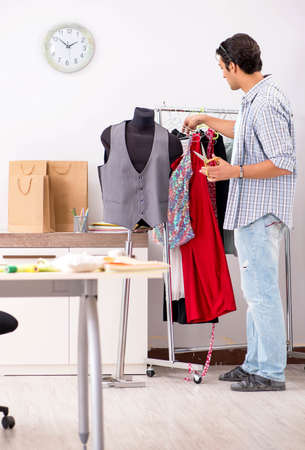 The young handsome tailor working in his workshopの写真素材