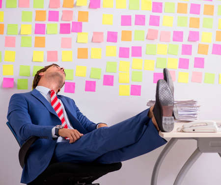 Young handsome man in conflicting priorities conceptの写真素材