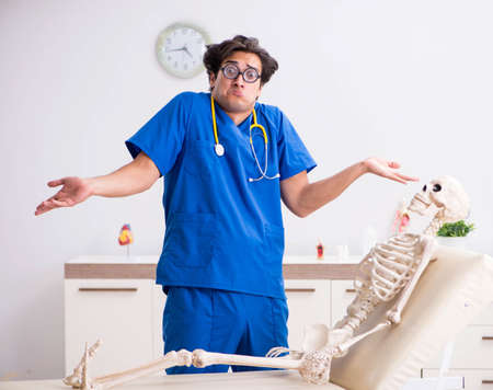 Funny doctor with skeleton in hospital