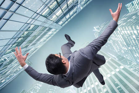 Concept of businessman in crisis free-falling from building